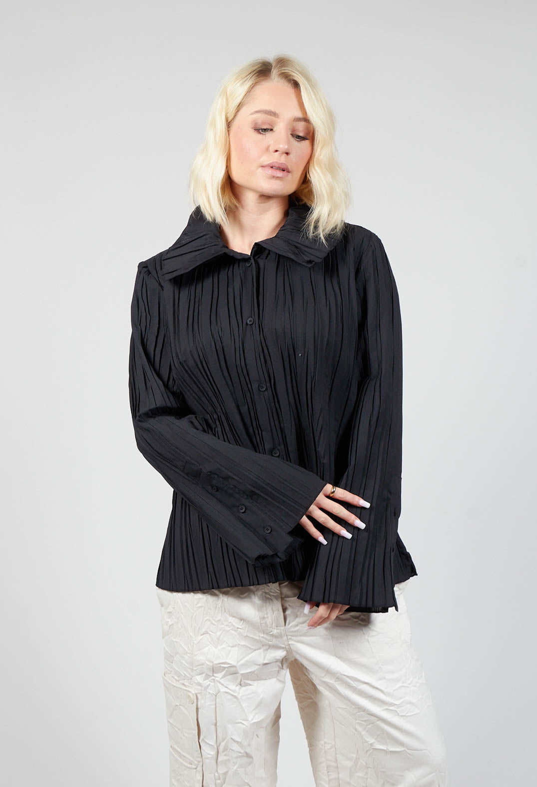 lady wearing a smart black blouse with button sleeves