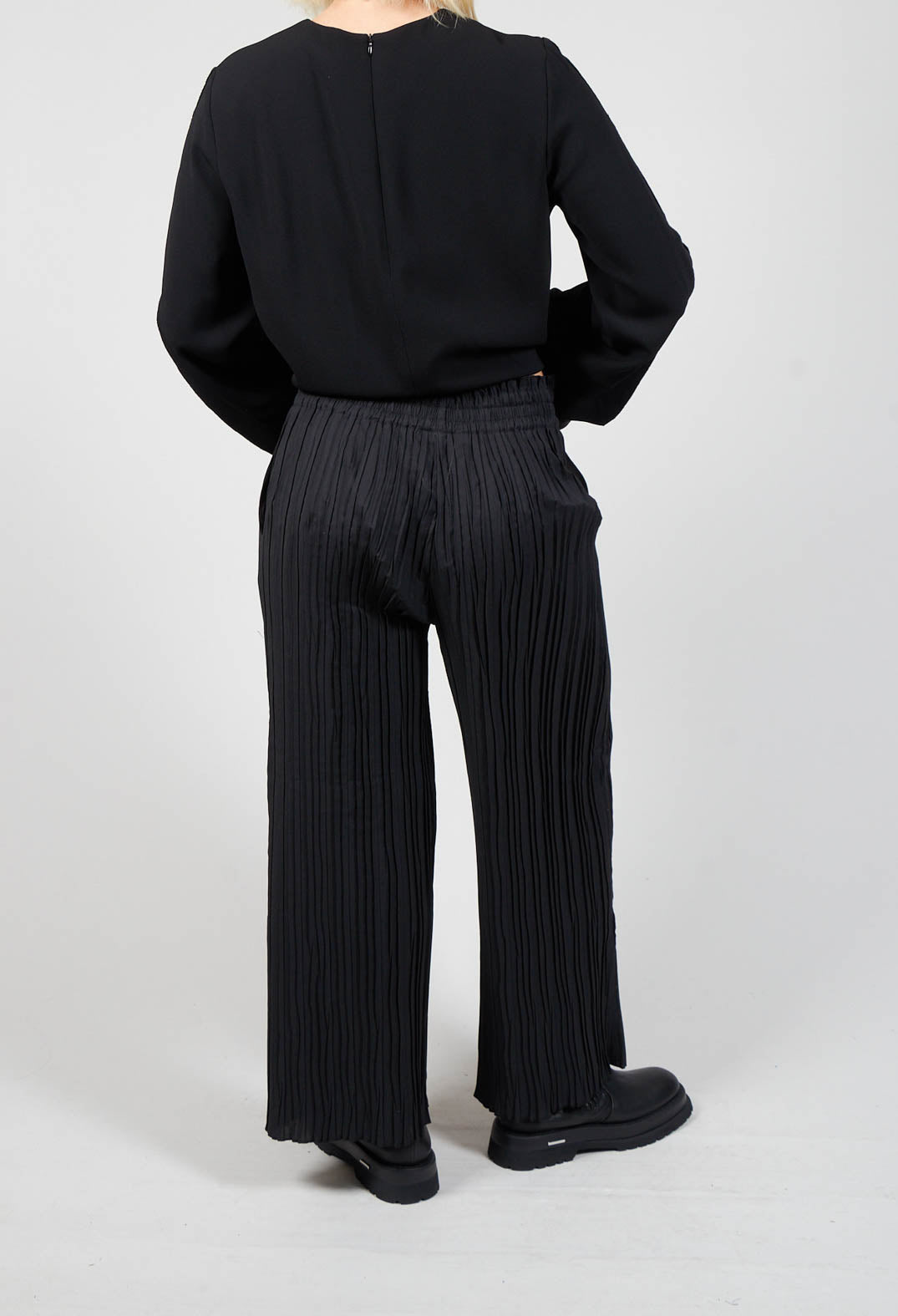 behind shot of ladies wide leg trousers in black and chunky black boots