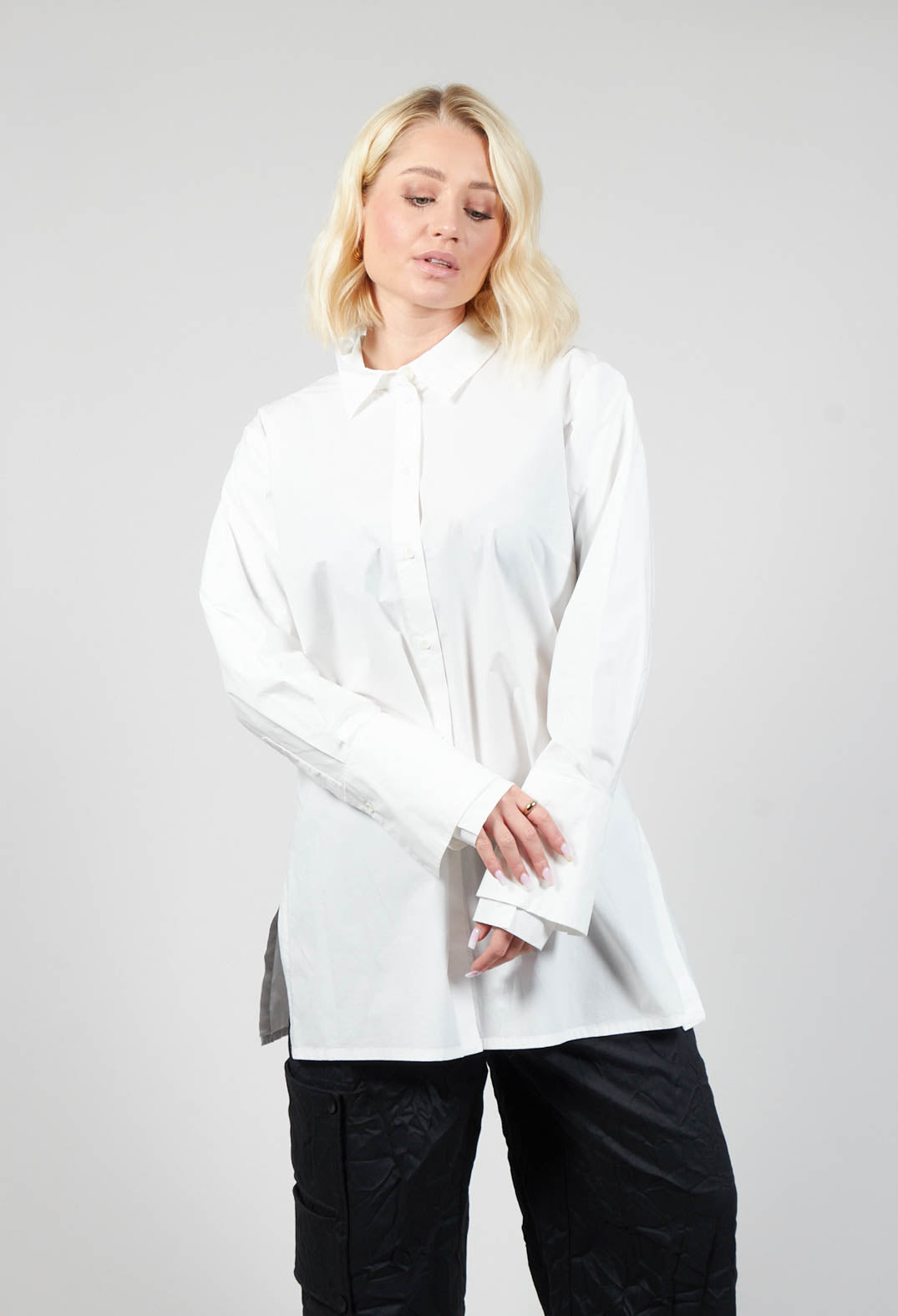 lady wearing an off white blouse with long sleeves and button fastening