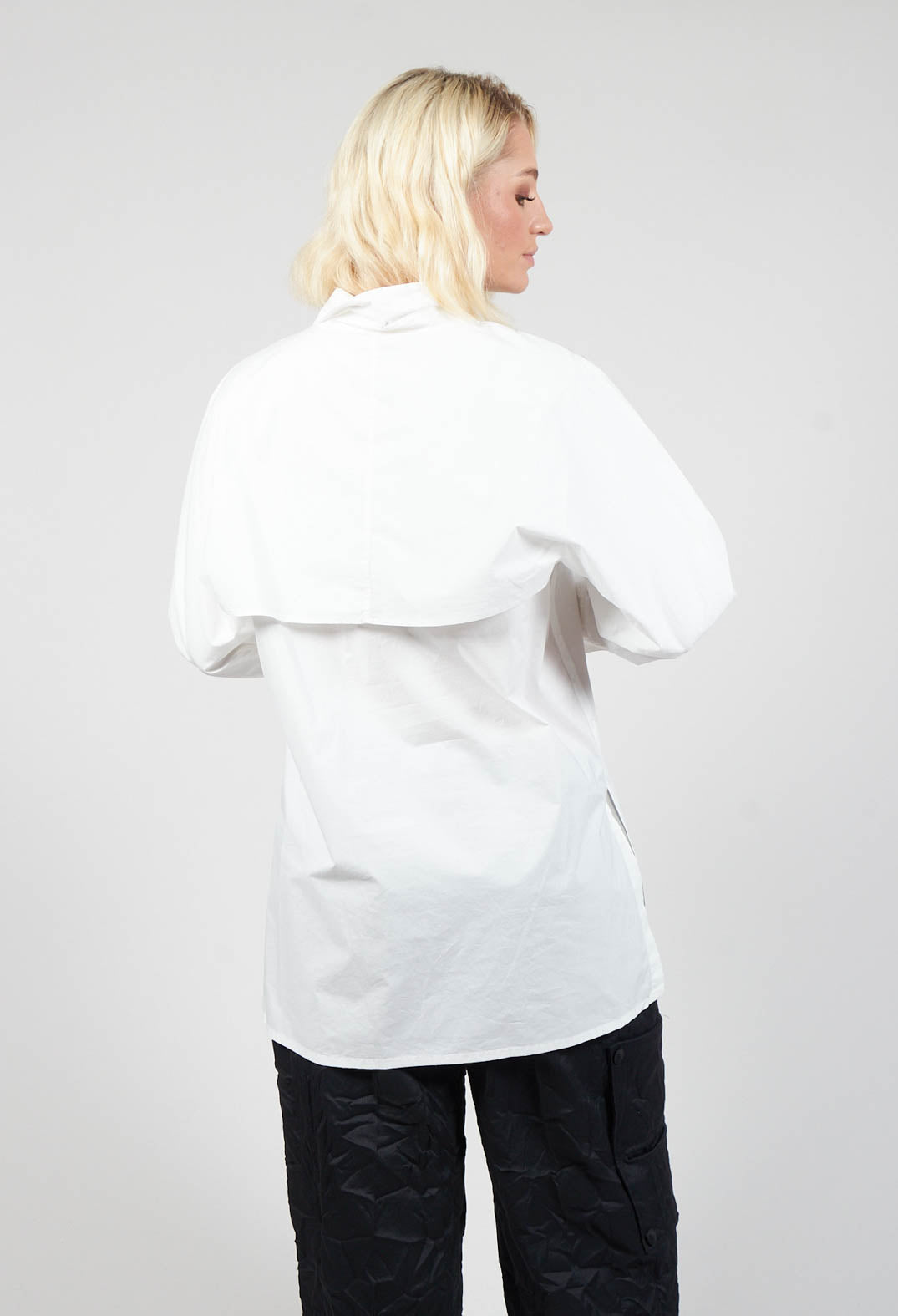 behind shot of ladies off white blouse with long sleeves