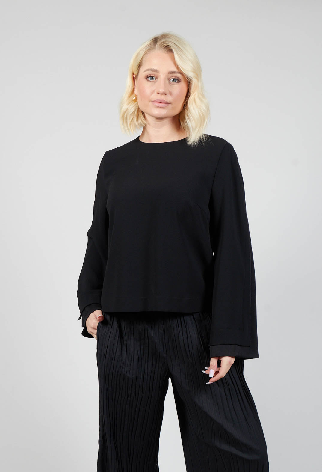 lady wearing a black blouse with wide leg trousers