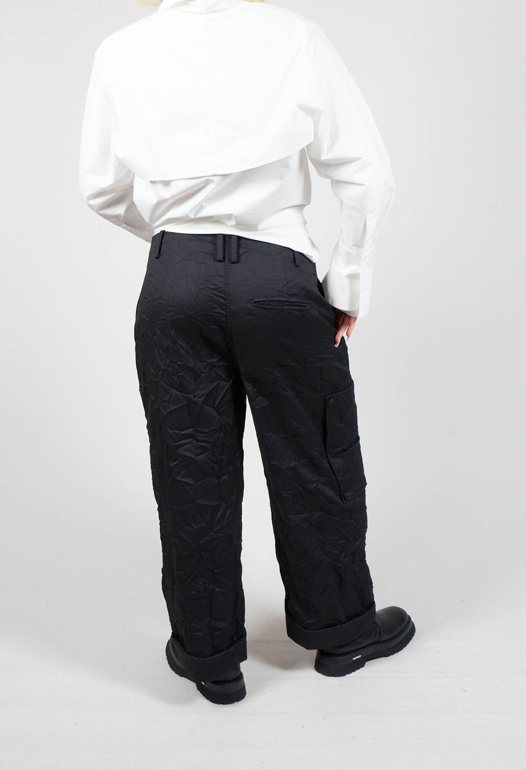 behind shot of person wearing black peka trousers and chunky black boots