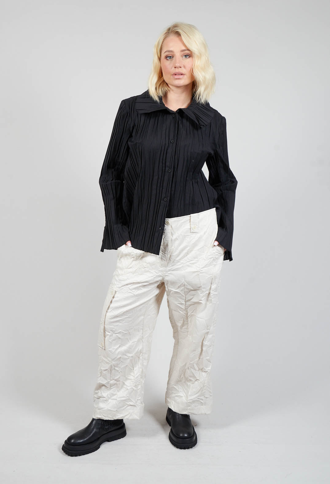 lady wearing off white peka trousers with her hands in side pockets