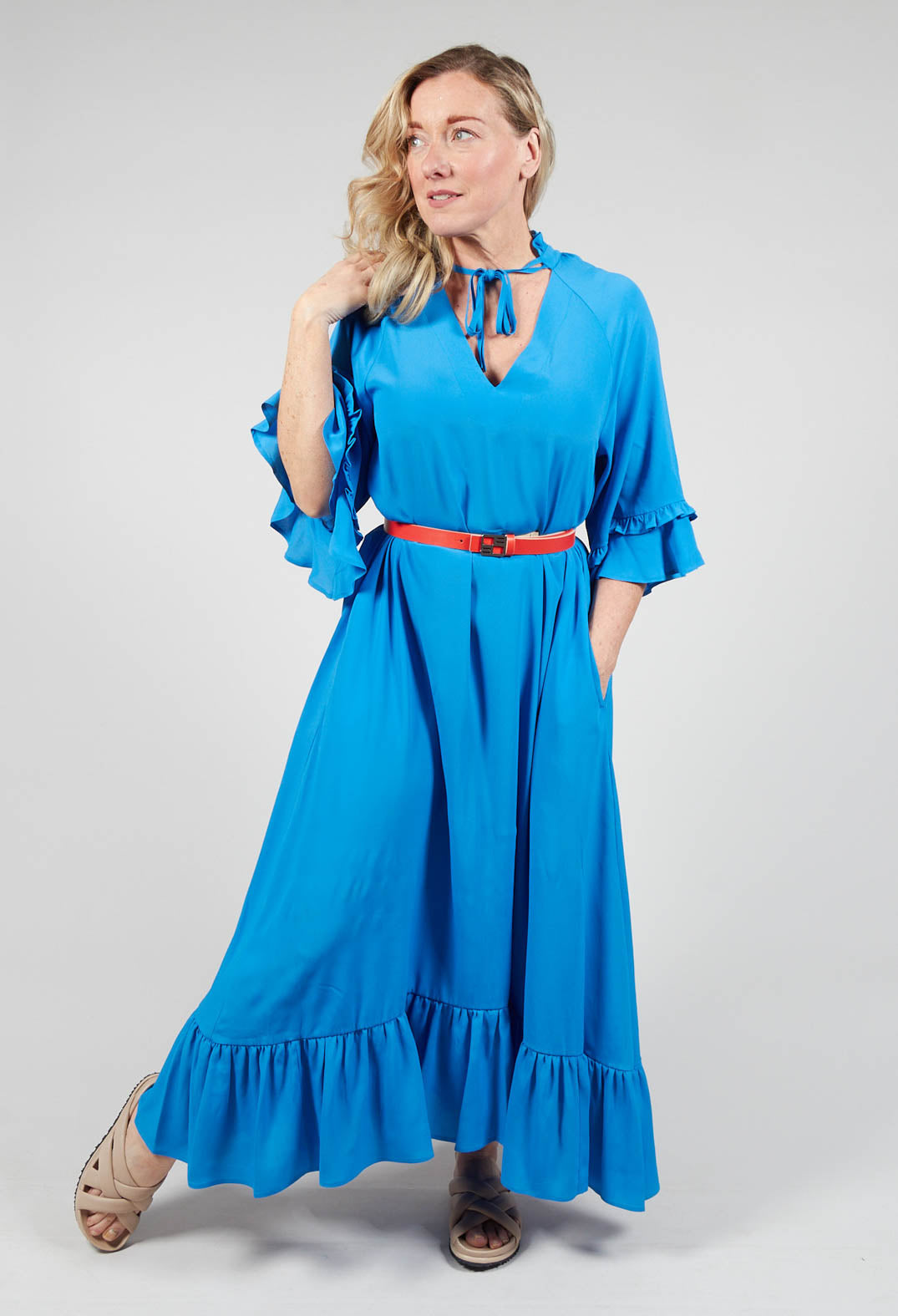 lady wearing blue dress with contrasting belt and pretty bell sleeves and neck tie detailing